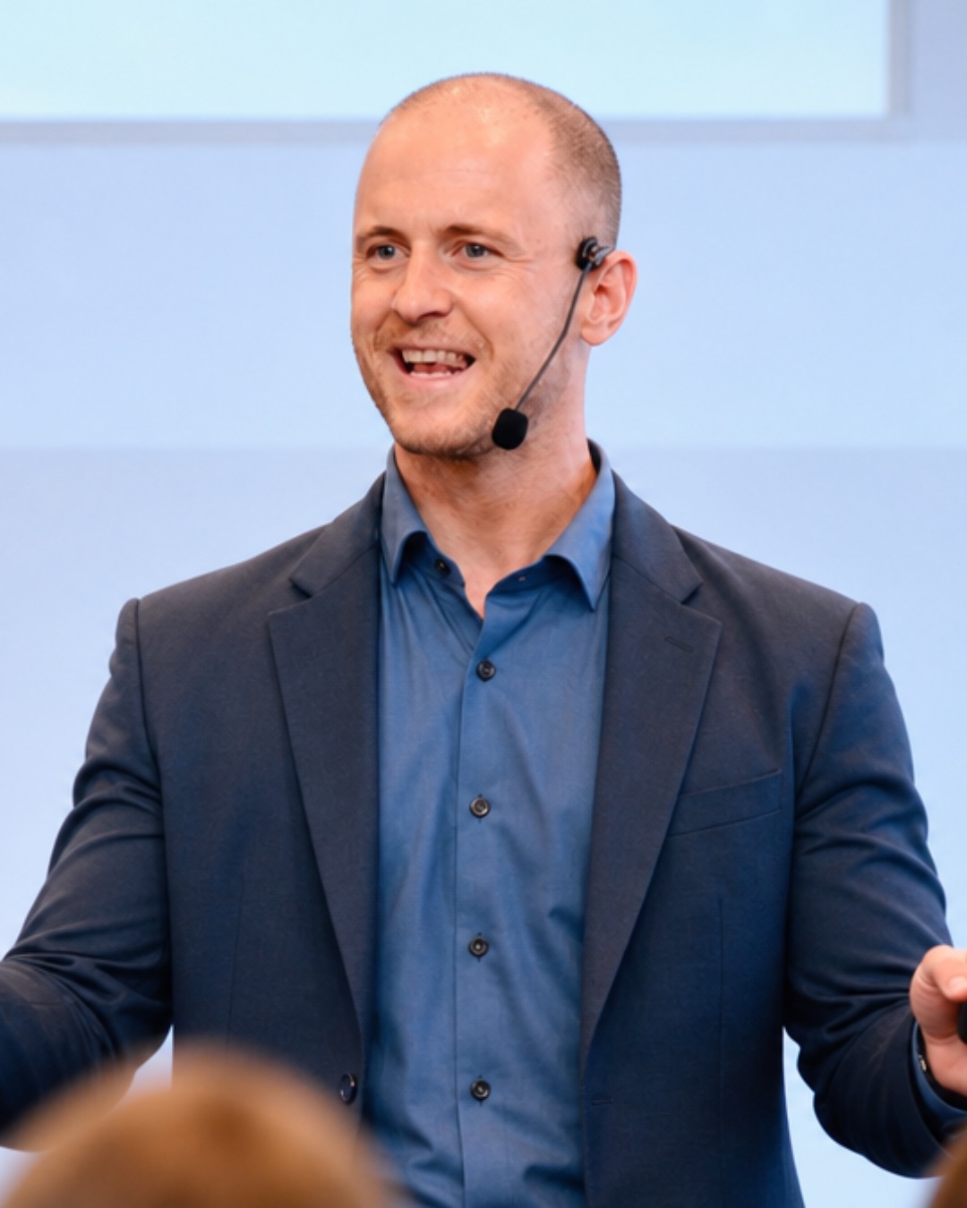 Philipp speaking and gesturing in front of a brick wall